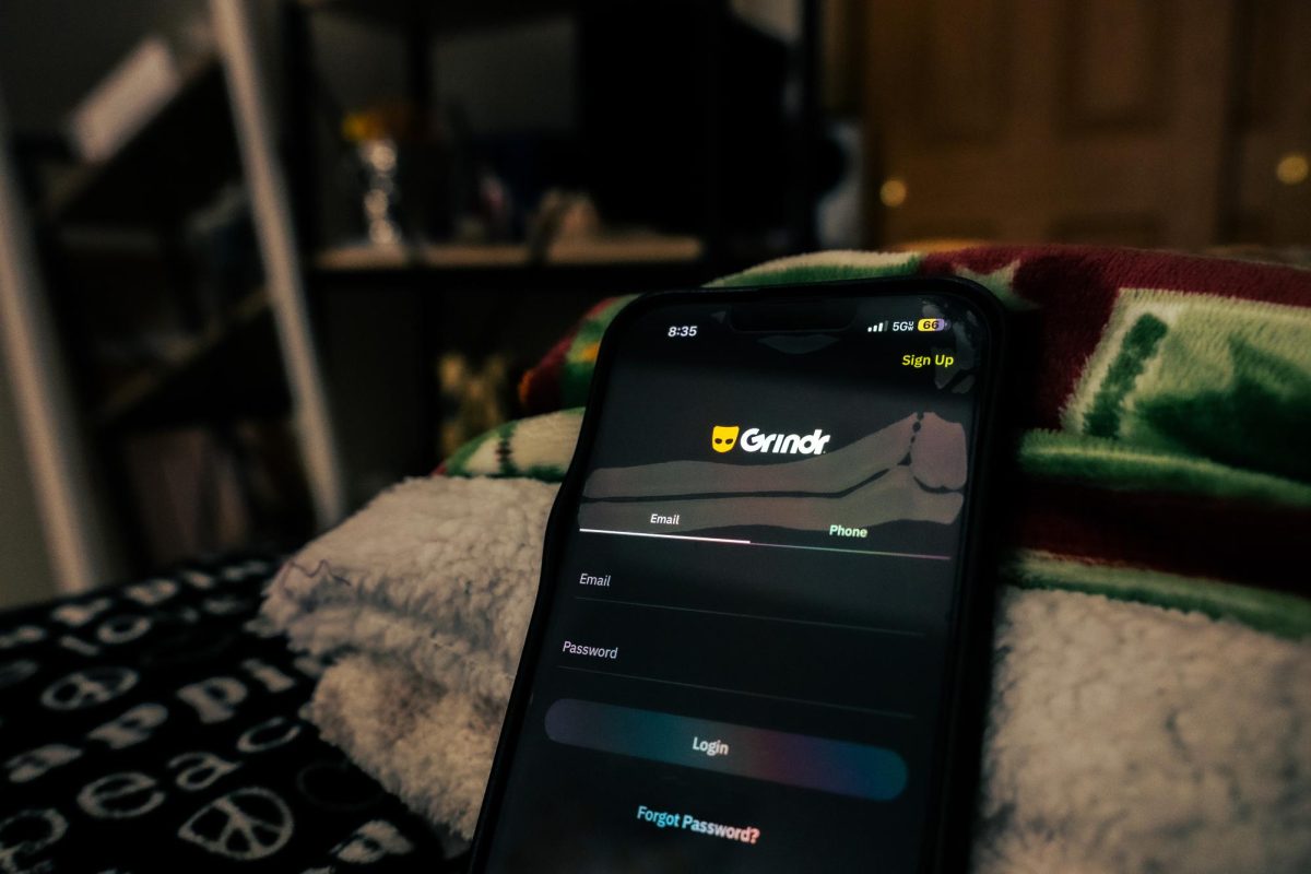 The sign in page to Grindr is displayed on an iPhone. Opinion Editor Gabe Santos believes “down low” men, or closeted gay men, in relationships should not cheat on their girlfriends with secret gay relationships. (Totus Tuus Keely | Northern Star)
