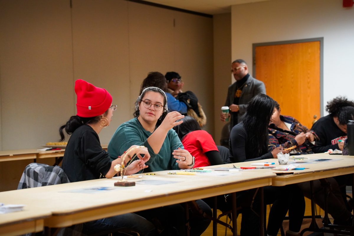 Attendees of Diaspora Day socialize while making beaded bracelets on Wednesday in the Capitol Room of the Holmes Student Center. The event was held to celebrate Black History Month and featured information on several African countries. (Ty McWilliams | Northern Star)