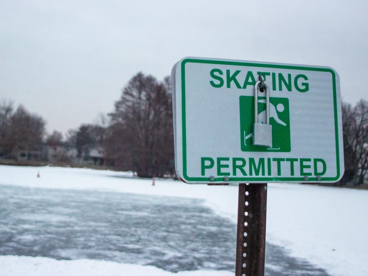 The East Lagoon is covered in snow and ice with a “skating permitted” sign displayed in front. Huskies on Ice will be hosted from 3 p.m. to 6 p.m. Friday at the East Lagoon for free ice skating. (Grace Kilbreath | Northern Star)