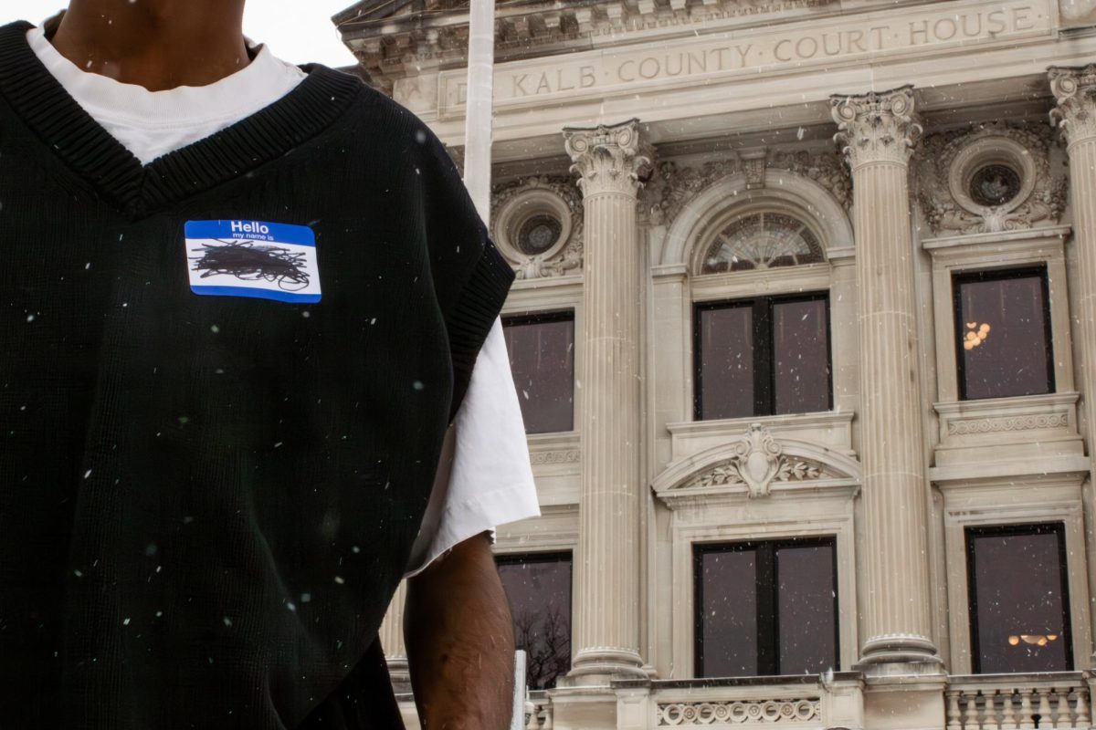A name tag with a scribbled out name is displayed on someone in front of the DeKalb County Courthouse, 133 W. State Street, on a snowy morning. Opinion Columnist Byrdie Seda believes that transgender people should be able to legally change their name for free as part of their gender expression. (Ethan Rodriguez | Northern Star)