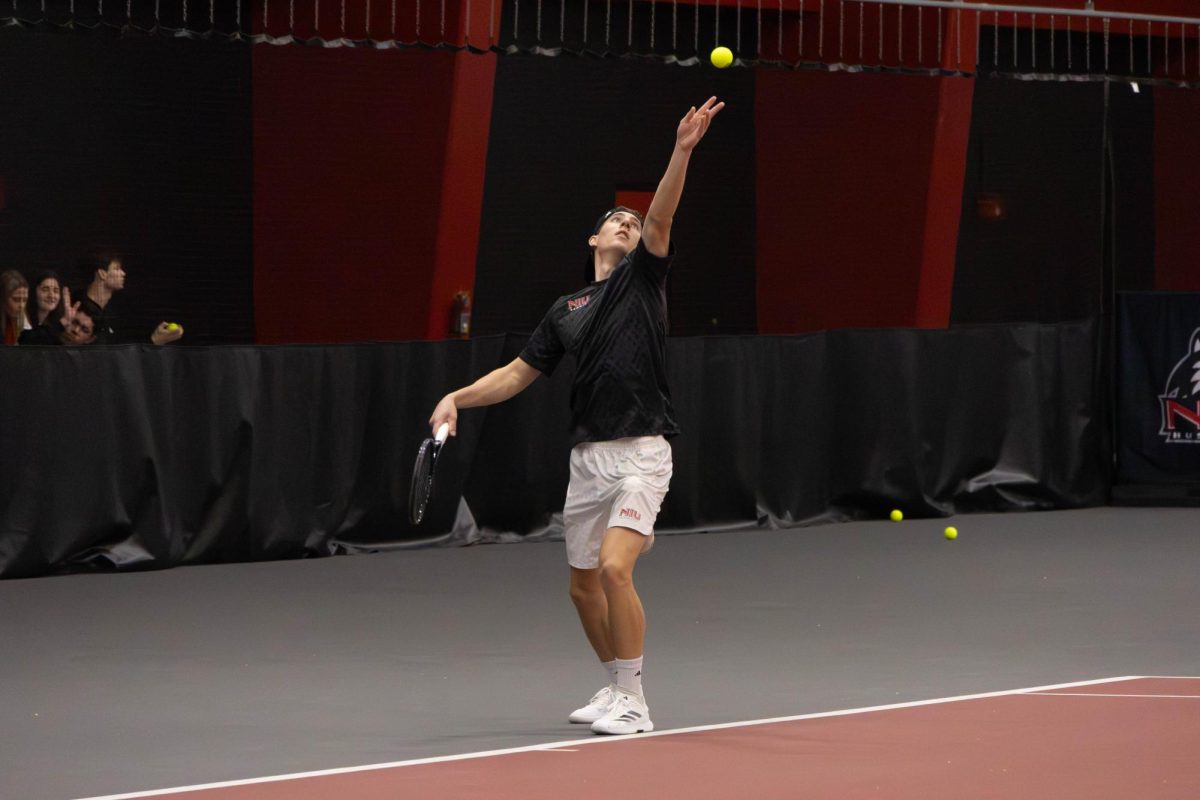 NIU men’s tennis sophomore Nikola Puntaric tosses the ball up for his serve in his singles match against Southern  University and A&M College on Feb. 13. The Huskies were swept in a 7-0 loss to the University of Wisconsin-Madison on Saturday. (Northern Star file photo)
