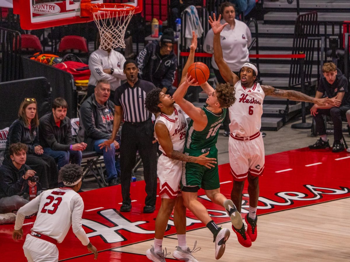 NIU men’s basketball freshman guard Taj Walters (6) and freshman guard Dylan Ducommun (25) contest Ohio University senior forward Aidan Hadaway (10) during Saturday’s game in the Convocation Center. NIU lost to the Bobcats 74-66, dropping the Huskies to 4-10 in Mid-American Conference play. (Eric McGill | Northern Star)