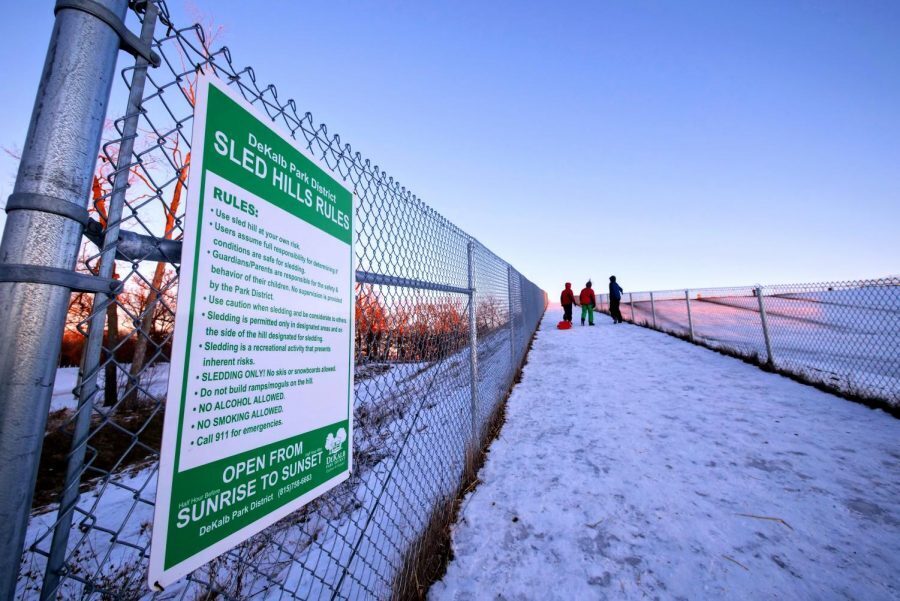 A sign for a sled hill sits on a fence on a snowy day on Jan. 21, 2021, at Hopkins Park, 1403 Sycamore Road. The 10th annual Polar Palooza will be held from noon to 3 p.m. Saturday at Hopkins Park and include sled dog demonstrations, winter hayrides, winter crafts and sledding depending on weather. (Northern Star File Photo)