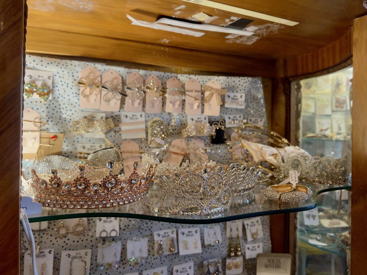 Jeweled tiaras and accessories sit displayed in a glass case at Cracker Jax, 118 N. 3rd St. Opinion Columnist Byrdie Seda believes child beauty pageants are exploitative of the children who participate. (Sofia Howell | Northern Star)