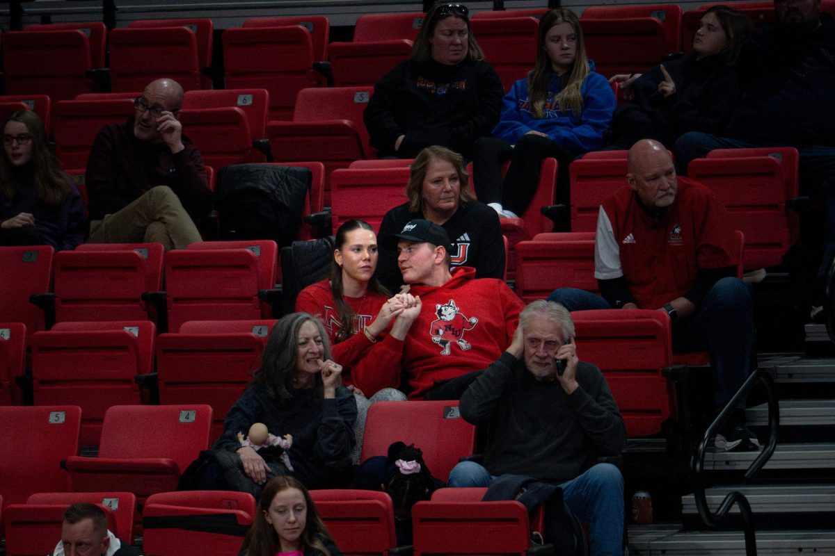 Kyle Sorenson (middle-right), resident of North Liberty, Iowa, and brother of NIU women’s basketball freshman guard Emilie Sorensen, holds hands with his girlfriend of 2.5 years Kylee Stock, resident of North Liberty, Iowa, while watching NIU women's basketball in the Convocation Center. Sports Writer Claire Valenti shares ways to score points with your date at sports events. (Totus Tuus Keely | Northern Star)