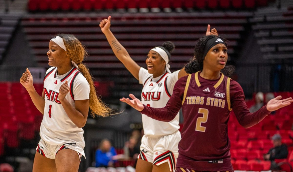 NIU women’s basketball senior forward Teresa Mbemba (1) and junior forward Nevaeh Wingate (8) celebrate a foul called on Texas State University sophomore guard KP Parr (2) during Saturday’s game in the Convocation Center. The Huskies shot 12/16 from the free throw line, helping lead to their 71-69 victory on Saturday. (Eric McGill | Northern Star)