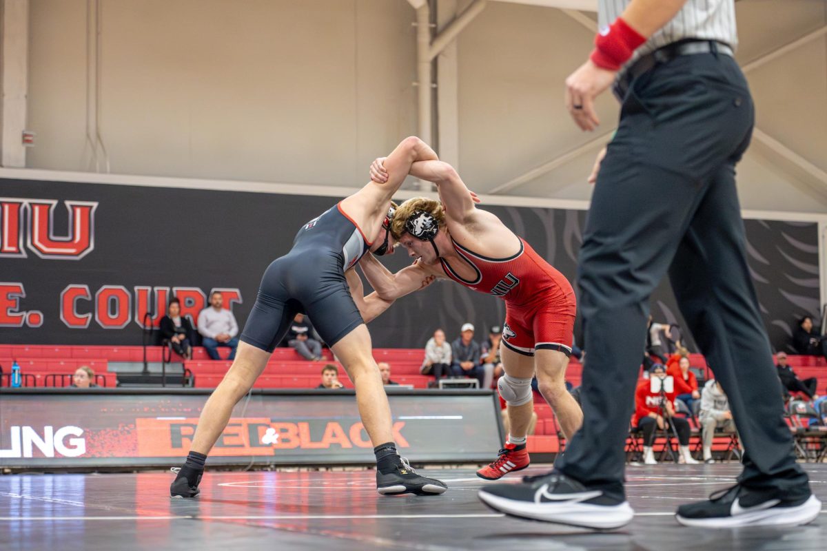 
NIU wrestling redshirt sophomore wrestler Brett Smith (right) and redshirt freshman Colin Young cross arms before Young claimed the 165-pound match 8-1 during the Red-Black Dual on Oct. 30. The Huskies dominated Northwestern University on Friday, taking a 28-9 victory. (Northern Star file photo)