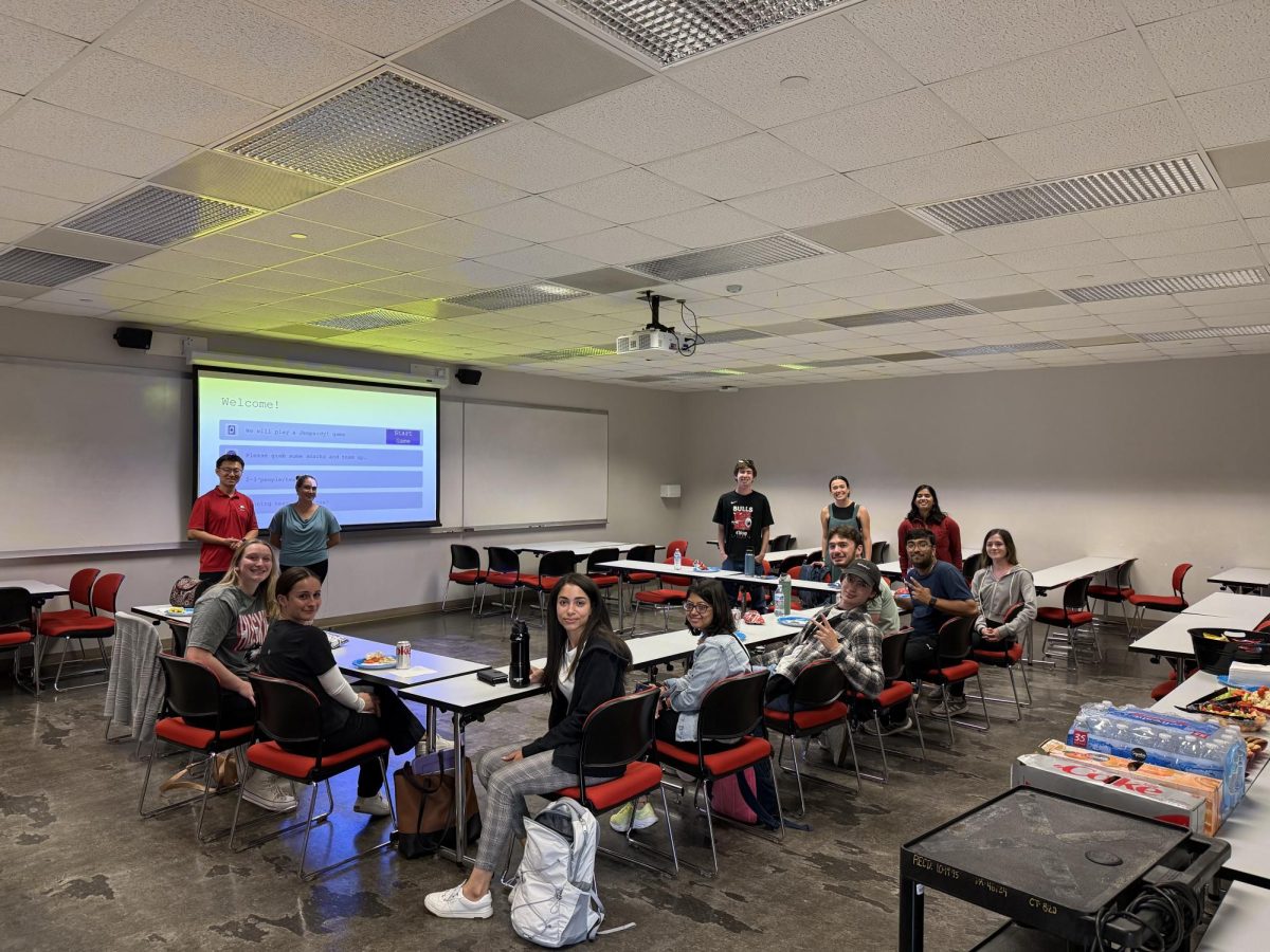 Members of NIU AI LEADS smile for a group photo during a team meeting. AI LEADS has recently been developing an early autism screening tool that analyzes children’s walking gait. (Courtesy of Hope Larson)