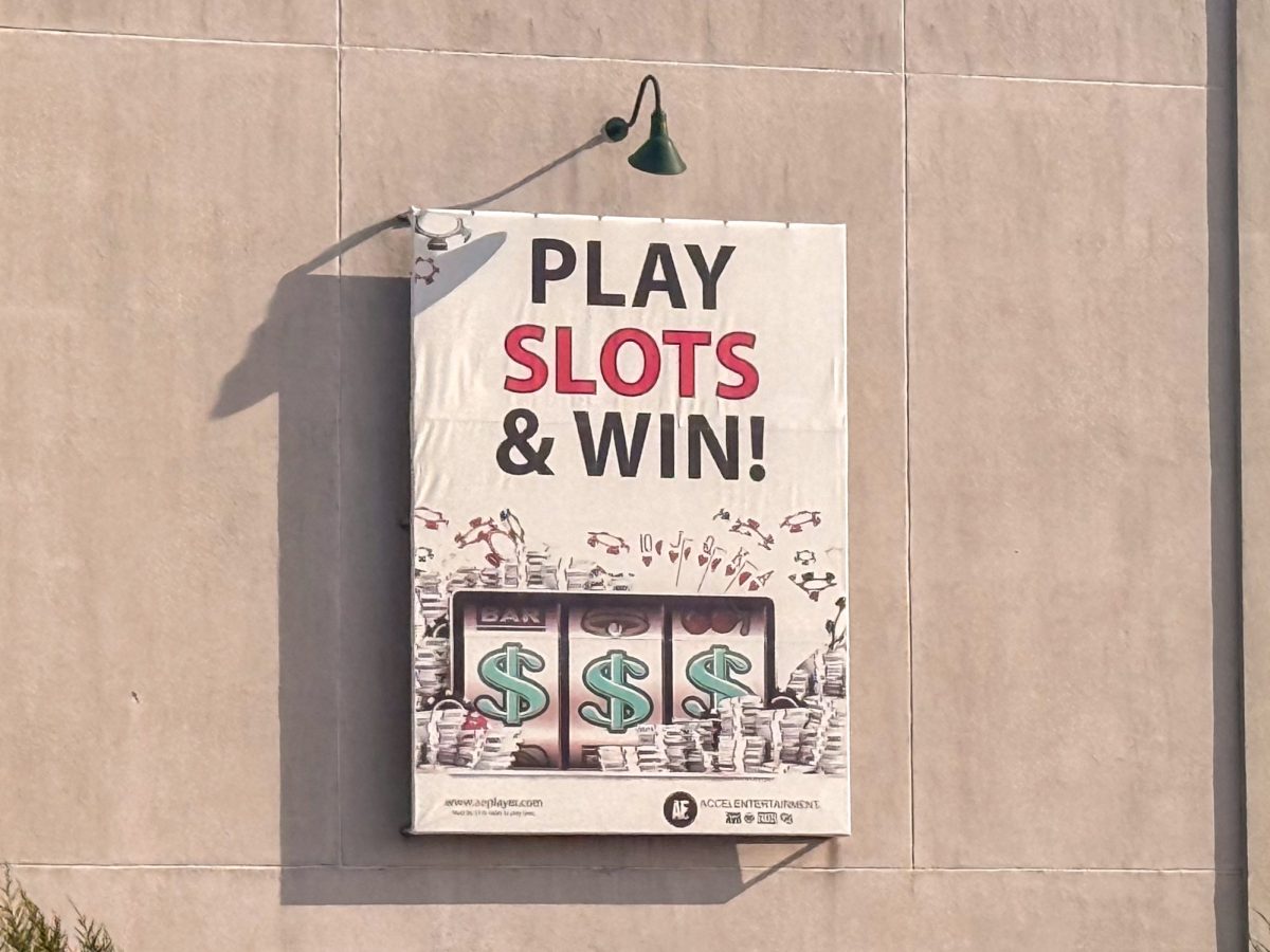 A poster hangs on a wall advertising a gambling business. Opinion columnist Byrdie Seda believes more regulation should be placed on gambling and sports betting ads. (Kaler Muñoz Ramirez | Northern Star)