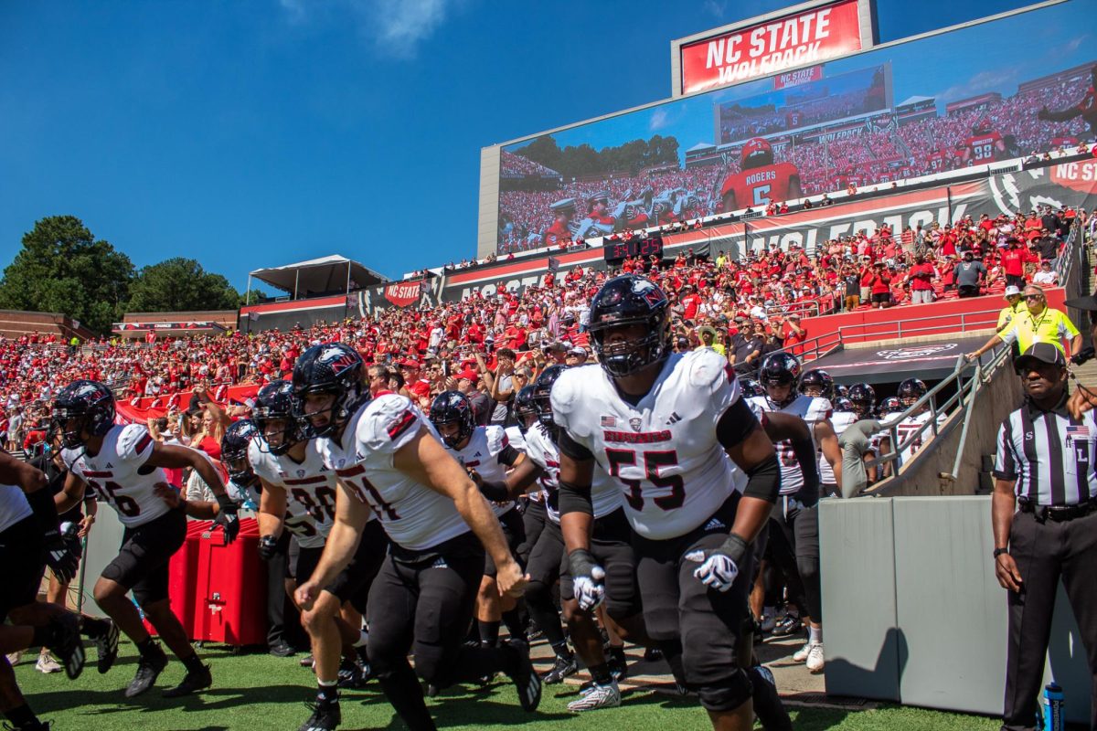 NIU football players run onto the field before a regular-season game against North Carolina State University on Sept. 28, 2024, at Carter-Finley Stadium in Raleigh, North Carolina. NIU is scheduled to face several Power Four opponents in future seasons. (Totus Tuus Keely | Northern Star)