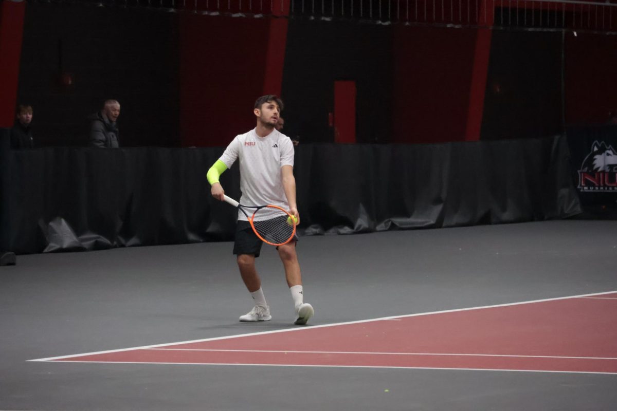 NIU men’s tennis sophomore Lorenzo Leti Messina prepares to serve in his singles match against Indiana University Indianapolis on Jan. 23. The Huskies dropped a 4-3 match to Drake University on Monday, losing consecutive matches for the first time this season. (Northern Star file photo)