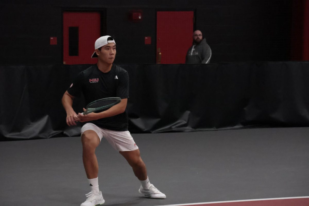 NIU men’s tennis sophomore Chiao Bo Suo Nan slides during his singles match against Grinnell College sophomore Aman Kothari on Sunday in the Chick Evans Field House. The Huskies defeated the Pioneers 7-0. (Sanaa Scott | Northern Star)