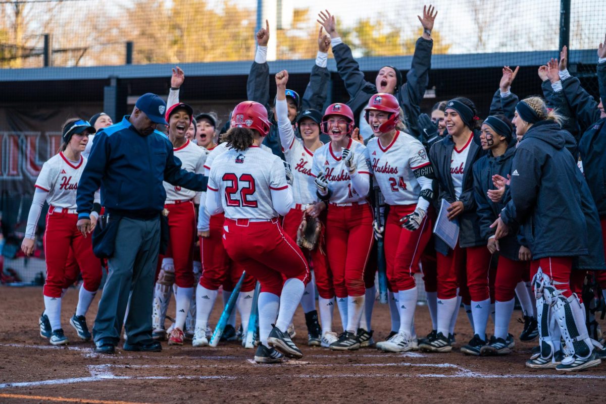 NIU softball senior pitcher/utility player Danielle Stewart (22) is cheered on by her teammates after she gives the Huskies the lead with a home run in game two against the University at Buffalo on Friday at Mary M. Bell Field. The Huskies split their double-header with the Bulls then claimed the weekend series with a 16-8 win against the Bulls on Saturday. (Eric McGill | Northern Star)