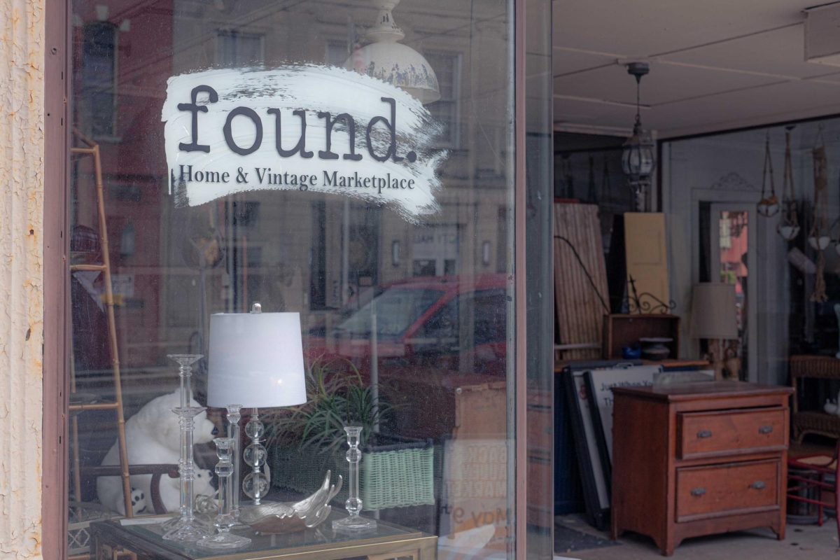 Antique items line the windows on Saturday in the storefront of found. Home and Vintage, 153 E. Lincoln Highway. The store, and the cats that roam inside, can be visited from 10 a.m. to 5 p.m. Thursdays through Saturdays. (Totus Tuus Keely | Northern Star)