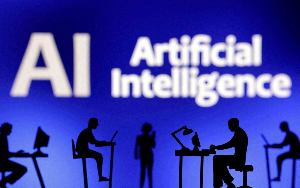 Figurines with computers and smartphones are pictured in front of the words Artificial Intelligence “AI." Opinion Columnist Byrdie Seda believes "ghost jobs" and AI chatbots is making it harder to land a job. (Dado Ruvic | REAUTERS)