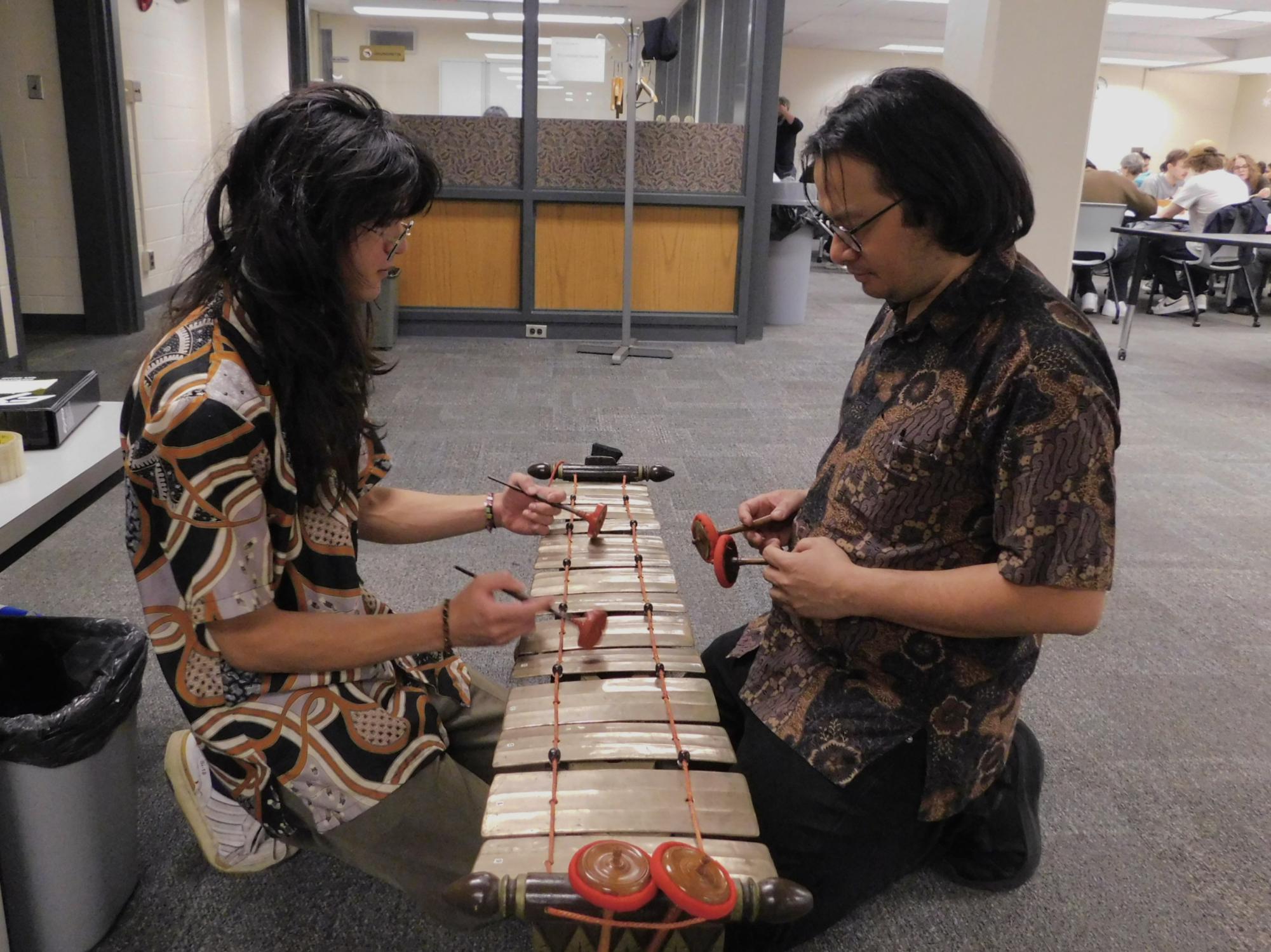 Second-year World Music masters student Gabriel Roethle (left) teaches Rafif Imawan, third-year political science doctoral student, the Javanese gendèr during the Harmoni Indonesian: Batik Event on Thursday in Watson Hall. The Indonesian class held their annual Batik event featuring traditional Indonesian musical performances, food and crafting Batik artwork. (Sofia Howell | Northern Star)