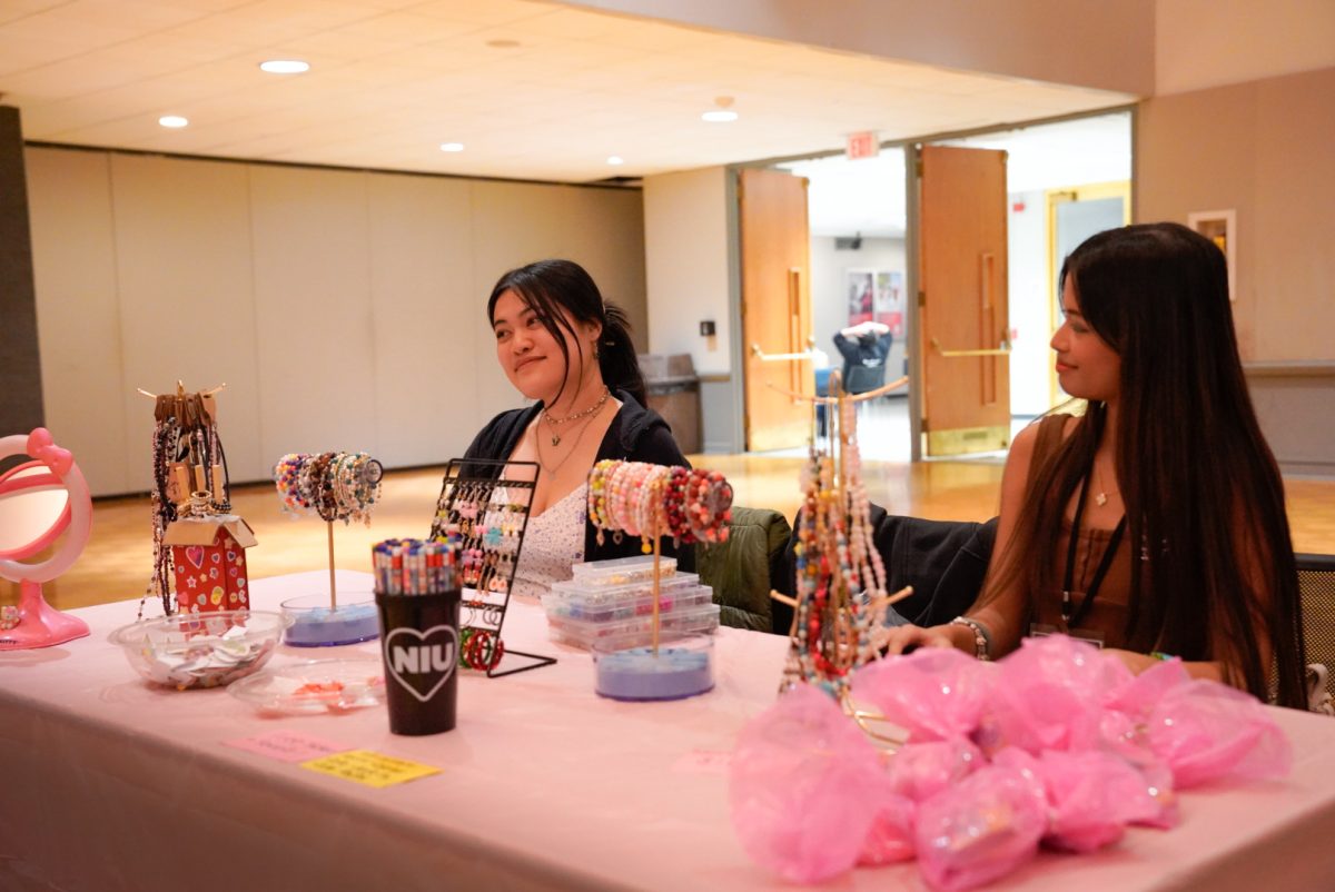 Odessa Haw Tay (left), an art education senior, and Faith Mesina, a studio arts sophomore, sell an assortment of beaded jewelry at the Campus Creators Market on Feb. 10 in the Duke Ellington Ballroom in the Holmes Student Center. The pair run their business, Jueforia, specializing in beaded jewelry. (Ty McWilliams | Northern Star)
