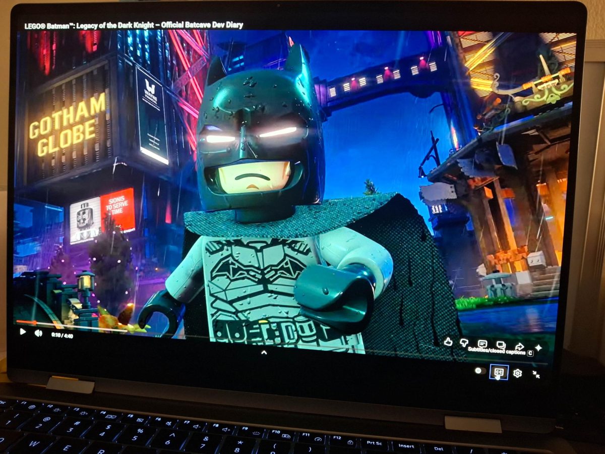 The “LEGO Batman: Legacy of the Dark Knight” trailer plays on a laptop screen. The game is set to release on May 22 of this year on the PlayStation 5, Xbox Series X|S, Nintendo Switch 2, and PC. (Sanaa Scott | Northern Star)