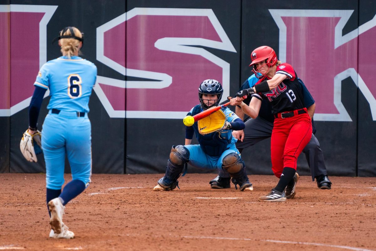 NIU senior catcher Rylie Hartman (13) hits a double during the first game of a doubleheader against Kent State University on Saturday at Mary M. Bell Field in DeKalb. Hartman had a .625 batting average with 10 hits across the Huskies' two Mid-American Conference series against Ball State University and Kent State. (Eric McGill | Northern Star)