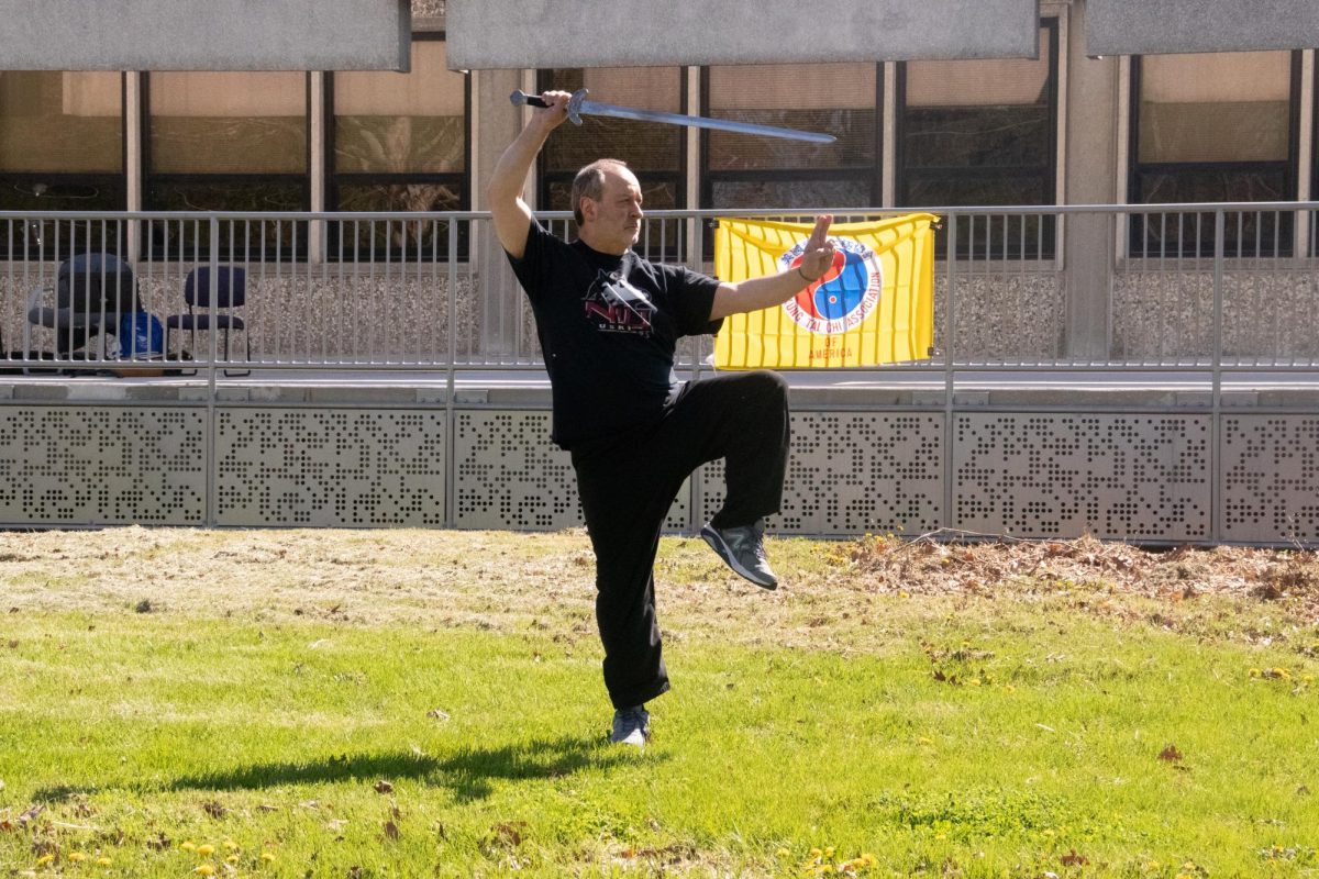 NIU professor Paul Wright demonstrates a straight sword Tai Chi form for World Tai Chi and Qigong day on the Anderson Hall front lawn on Saturday. “World Tai Chi & Qigong Day,” is an annual global event that is observed in over 80 nations including New Zealand, India and the United Kingdom. (Roshay Grant | Northern Star) 
